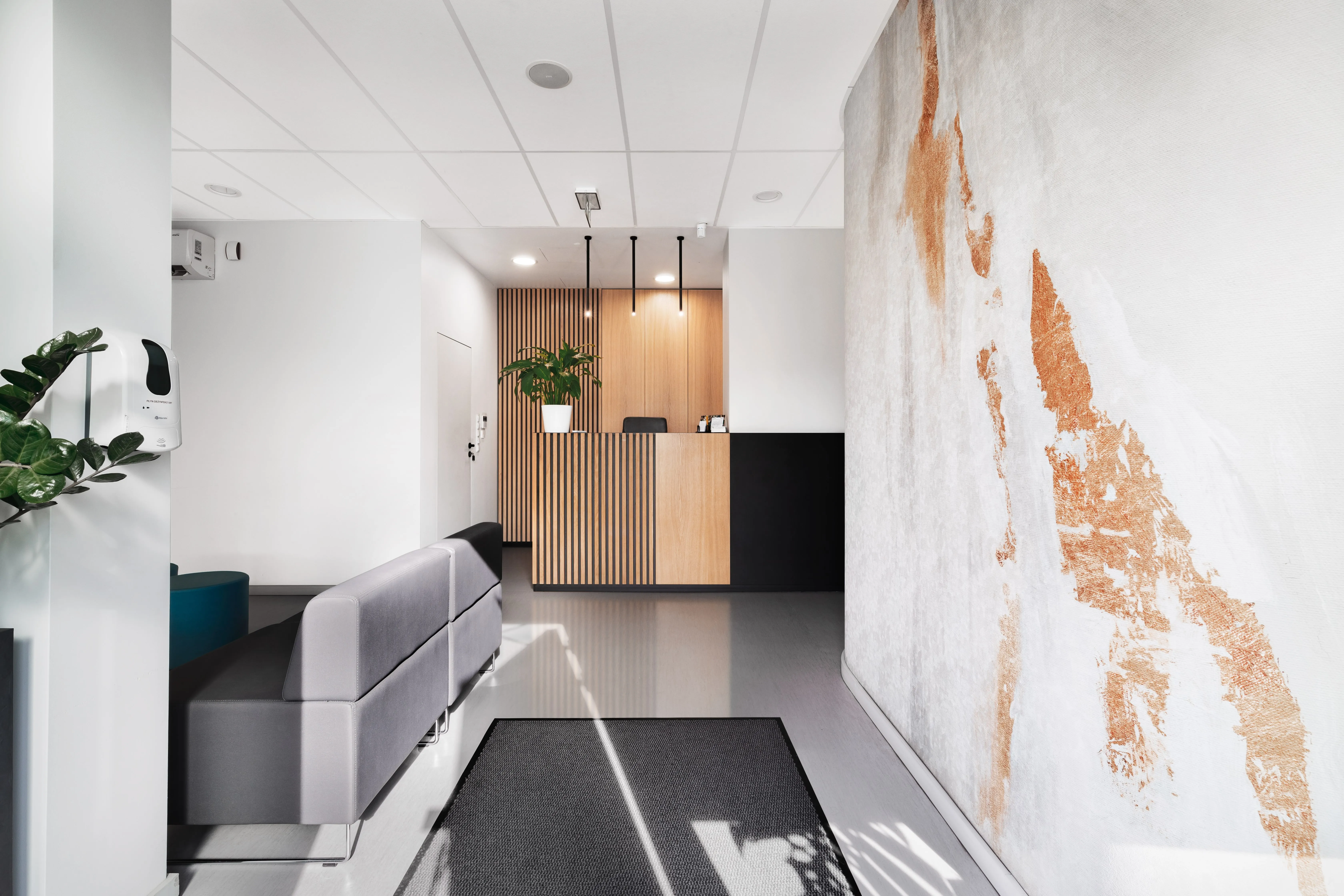 Recepcja z drewnianą ladą i dekoracyjną ścianą